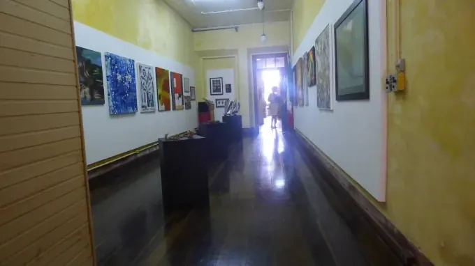Corredor da Casa d'Italia com exposição de arte nas paredes